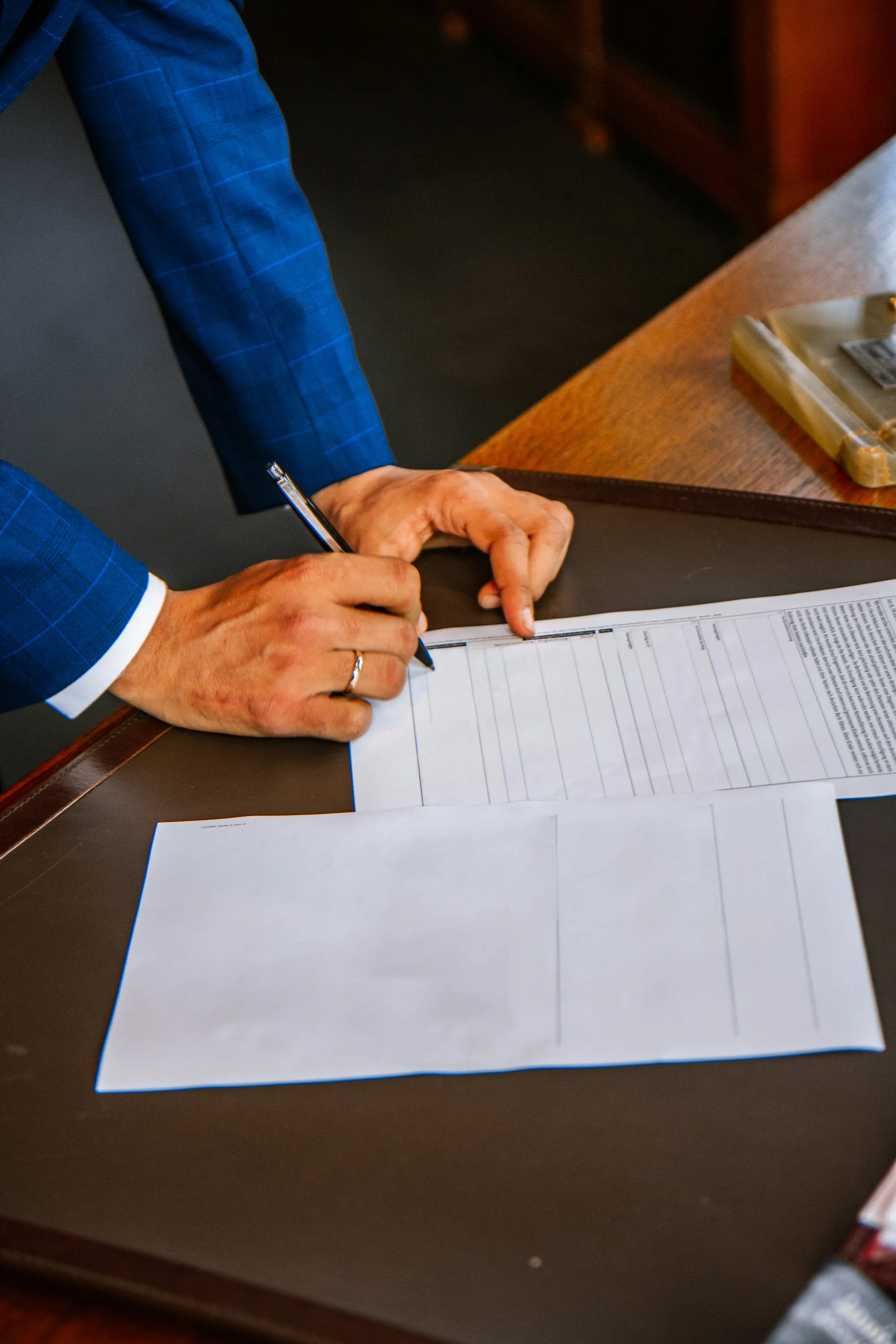 Hand filling out a printed form with a pen