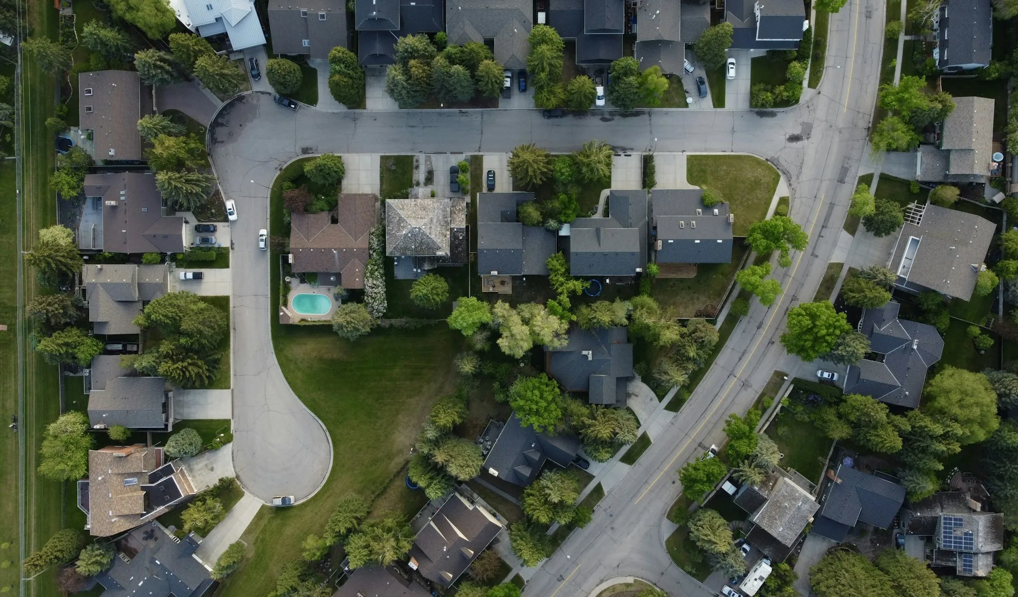 Aerial view of homes along a curving cul-de-sac with trees