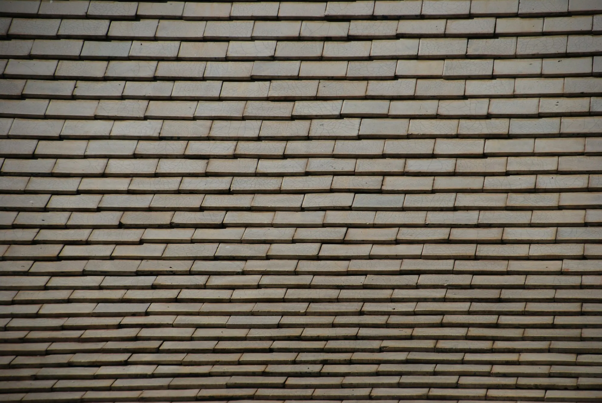 Low-angle close-up of rows of brown asphalt shingles, the kind of roof New Lenox homeowners check before solar goes back on